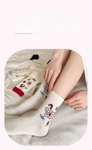 Gros plan sur chaussettes en coton crème avec imprimé dessin animé et bords côtes élastiques