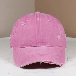 Detailed view of pink distressed cotton baseball cap showing worn edges and vintage look