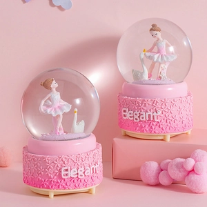 Detailed view of pink ballerina and swan snow globe music box with Elegant base