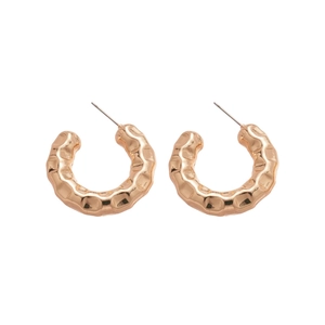 Minimalist golden C-shaped hoop earrings with unique hammered texture on white background