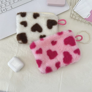 Macro view showing soft plush material and cute heart pattern on compact coin pouches