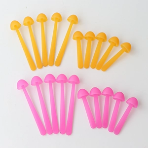 Macro shot of colorful silicone mushroom stir sticks in yellow and pink variations