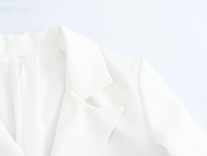 Detail of white blazer lapel and shoulder line with premium tailored fabric texture