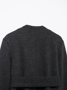 Detailed close-up of dark grey wool blend fabric texture and stitching on the back of the coat
