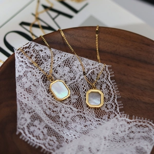 Elegant 18K gold-plated stainless steel necklace with hexagonal shell pendant on wood