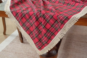 Dettaglio della tovaglia natalizia a quadri rossi e verdi con nappe con frange beige