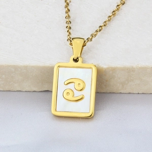 Detailed macro view of a gold square Cancer zodiac pendant with a white shell inlay