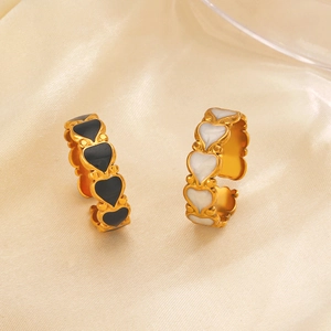 Minimalist adjustable open gold rings with black and white enamel heart designs on silk