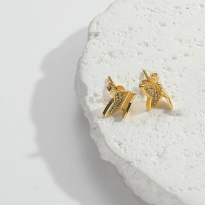 Detailed macro view of golden butterfly stud earrings with micro-pave cubic zirconia crystals