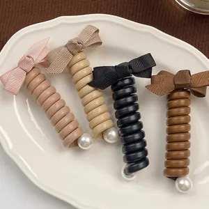 Lot de quatre élastiques à cheveux torsadés avec nœud et perle en couleurs chaudes