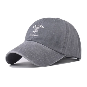 Detail of gray washed cotton baseball cap with white rose and slogan embroidery