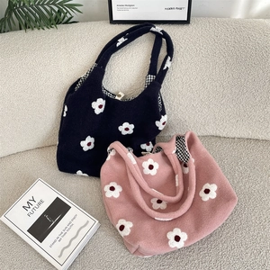 Detail of floral embroidery on plush tote bags with stylish checkered lining fabric