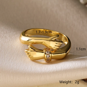 Macro shot of gold-plated embrace ring with cubic zirconia stones on silk background
