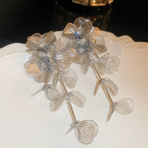 Detailed shot of silver flower earrings with long tassels and rhinestones on a plate