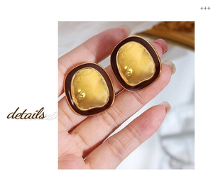 Macro detail of vintage textured gold center with dark enamel border earrings
