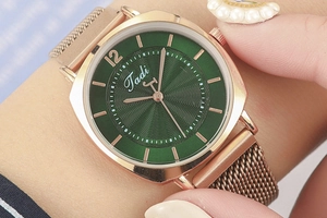 Détail du cadran vert à effet soleil et du bracelet en maille milanaise dorée rose