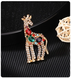 Macro shot of gold-plated giraffe brooch with colorful gemstones and rhinestones