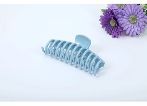 Macro shot of large 13cm light blue glossy hair claw clip on minimalist white background