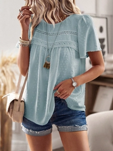 Detail of light blue short sleeve top featuring lace patchwork and textured polka dots