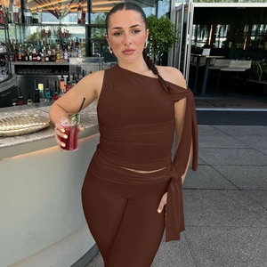 Detail of a brown one-shoulder knit crop top and matching slim trousers set on a model