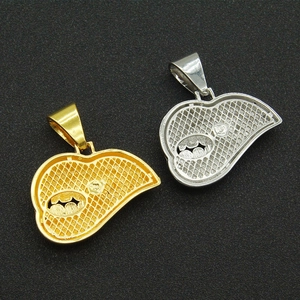 Macro shot of hip hop style lip pendants in gold and silver finish on textured black surface
