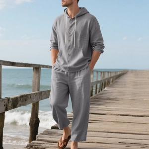 Men's grey linen beach set with hooded long-sleeved shirt and elastic trousers on seaside