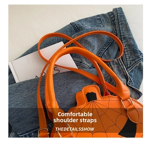 Detail of pumpkin crossbody bag showing the strap connector and black spider web pattern