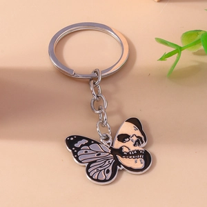 Gothic Halloween keychain featuring a black butterfly wing and skull pendant on silver ring