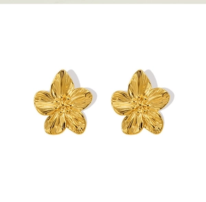 Dettaglio macro di orecchini a fiore in oro 18K con finitura in metallo spazzolato