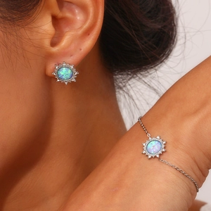 Detail view of silver starburst jewelry set with blue opal stones on model