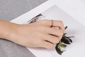 Gros plan d'une bague nœud en V dorée minimaliste sertie de diamants sur un mannequin