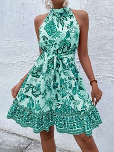Detail of mint green floral halter dress featuring a waist tie and ruffled hem design