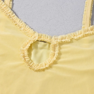 Detail of yellow mesh mini dress featuring layered ruffled trim and sheer fabric texture