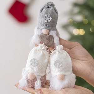 Three plush Christmas forest gnome hanging ornaments with knitted hats and warm lighting