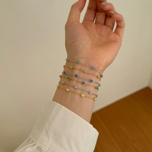 Close-up of gold and silver S925 sterling silver bracelets with opal stones on a wrist