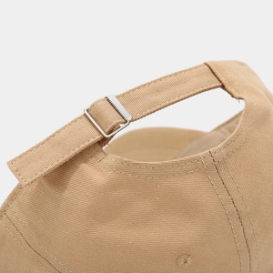 Close-up of khaki baseball cap featuring an adjustable metal buckle and twill fabric