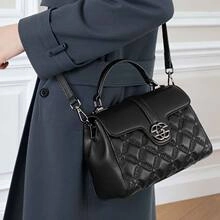 Detail of black woven leather tote featuring a metal ring buckle and quilted pattern