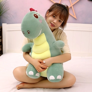 Close-up of a large green dinosaur plush toy showing soft fabric texture and yellow belly