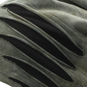 Close-up of tie-dye knit beanie showing distressed hole texture and striped fabric detail