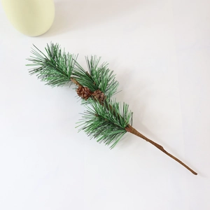 Detailed close-up of artificial green pine needles with two natural brown pine cones