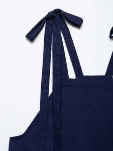 Detail of navy blue bow-knot shoulder strap and cotton linen fabric texture on summer set