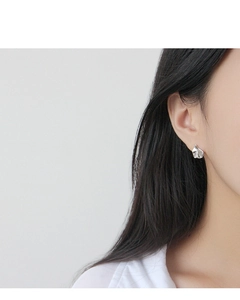 Gros plan sur un clou d'oreille minimaliste en argent S925 à texture irrégulière