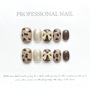Handmade press-on nails with leopard print, brown tones, and creamy 3D ribbon bows