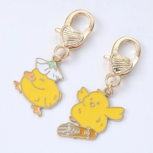 Cute yellow cartoon duck keychains with flower hat and skateboard in golden metal finish