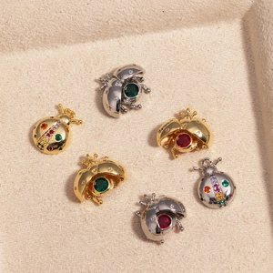 Golden and silver ladybug pendants with colorful zircon inlay on jewelry tray