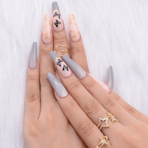 Long coffin fake nails with gray pink ombre, black butterfly patterns and gold line detail