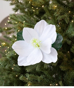 Close-up of white glittery lotus fabric flower on a Christmas tree with warm lights
