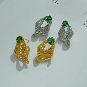 Irregular C-shaped earrings with hammered texture and emerald green zircon in gold and silver