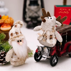 Detail of knitted Christmas gnome and reindeer dolls with pine cones and festive decor