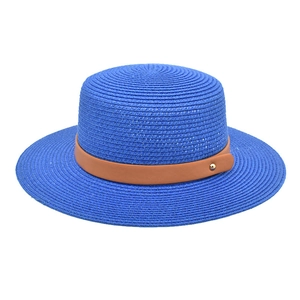 Detail of bright blue straw hat with a brown leather band and gold metal hardware